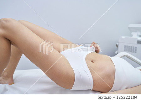 Female receiving laser hair removal treatment in clinic setting 125222184