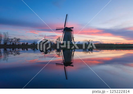 Windmills in the Netherlands during sunset. Historical architecture and buildings. Dutch canals Windmills in the Netherlands during sunset. Historical architecture and buildings. Dutch canals 125222814