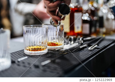 Mixing cocktails at an elegant bar during a lively evening gathering 125222969