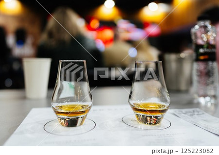 Sipping whiskey at a lively tasting event in an upscale venue 125223082