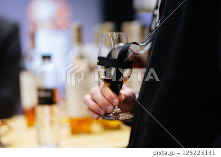 Elegant glass holding whiskey at a sophisticated tasting event 125223131