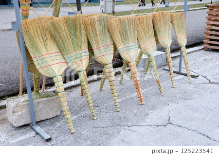 A Variety of Colorful Handmade Brooms Artfully Displayed for Sale to Attract Buyers A Variety of Colorful Handmade Brooms Artfully Displayed for Sale to Attract Buyers 125223541
