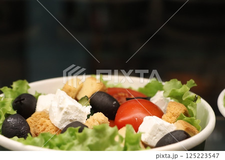 A delicious and refreshing Fresh Salad featuring vibrant Tomatoes, Olives, and creamy Feta Cheese 125223547