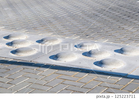 Textured tactile pads designed to enhance pedestrian safety and awareness on sidewalks 125223711