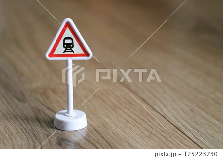 Warning Sign for Train Crossing placed on wooden floor for visibility and caution 125223730