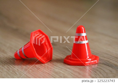 A Row of Colorful Traffic Cones Displayed on a Wooden Surface Beneath Natural Light 125223743
