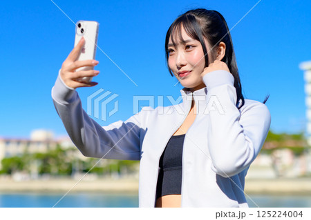 スマホを持つ手で自撮りするかわいい女性 セルフィー SNS 日常 映え トリミングアップ スマホを持つ手で自撮りするかわいい女性 セルフィー SNS 日常 映え トリミングアップ 125224004