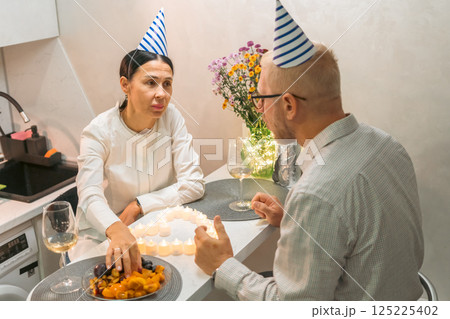 Birthday Couple Celebrating Modern Apartment Romantic Dinner, intimate birthday celebration for a couple in a contemporary apartment. 125225402