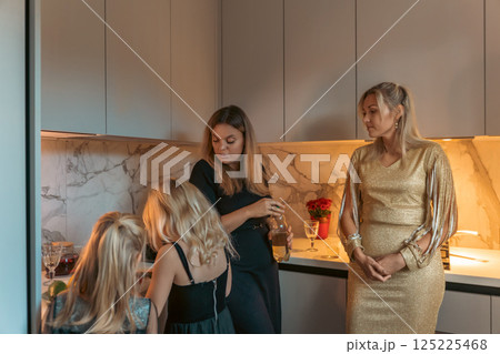 Women, Kitchen, Gathering: Modern apartment, evening, family celebration. Women, Kitchen, Gathering: Modern apartment, evening, family celebration. 125225468