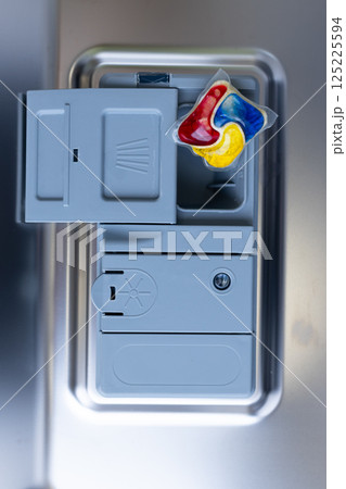 An Overview of a Washing Machine Detergent Dispenser Featuring Colorful Pods, Perfect for Convenient Laundry Cleaning in a Modern Home Environment. 125225594