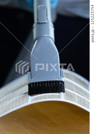 Detailed Close-Up of a Vacuum Cleaner Attachment Designed for Cleaning Hard-to-Reach Areas, Featuring a Brush Head and Textured Filter Material 125225754