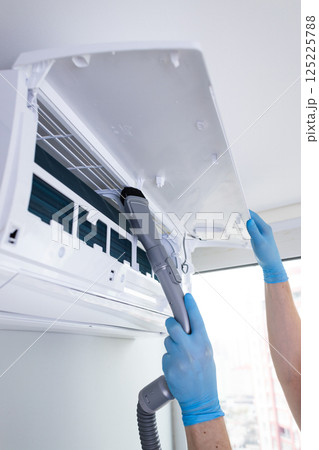 Efficient Air Conditioner Maintenance: Cleaning the Filter with Care for Optimal Performance and Longevity Efficient Air Conditioner Maintenance: Cleaning the Filter with Care for Optimal Performance and Longevity 125225788