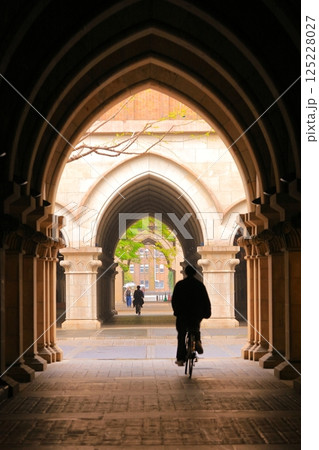 中世のイタリア的兼特物の中を通行する自転車に乗車する人のシルエット 中世のイタリア的兼特物の中を通行する自転車に乗車する人のシルエット 125228027