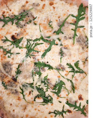 Delicious four cheese pizza with fresh arugula close up copy space 125229807