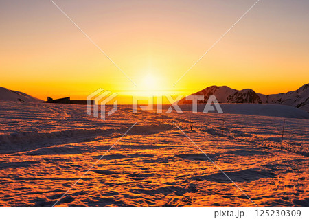 夕焼けの冠雪の北アルプスの立山の室堂 125230309