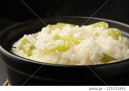 土鍋で炊いたふきの炊き込み御飯を茶碗に盛り付ける 125231841