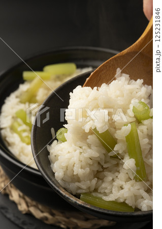 土鍋で炊いたふきの炊き込み御飯を茶碗に盛り付ける 125231846