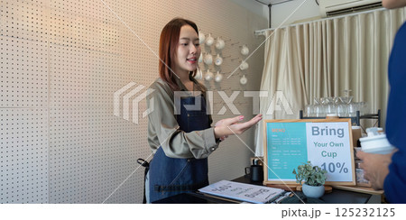 Sustainable Practices and Customer Interaction. A barista explaining eco-friendly initiatives at a cafe to a customer. Sustainable Practices and Customer Interaction. A barista explaining eco-friendly initiatives at a cafe to a customer. 125232125