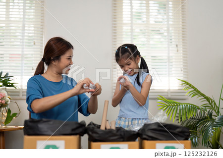 Eco-Friendly Family Time. A mother and daughter enjoying recycling together, setting an example for future generations. 125232126