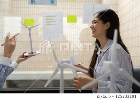 Engaging in ESG Strategies. A corporate professional shares insights on wind energy initiatives during a constructive meeting. Engaging in ESG Strategies. A corporate professional shares insights on wind energy initiatives during a constructive meeting. 125232191