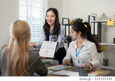 Diverse business team presenting project charts and data during a meeting. 125232343