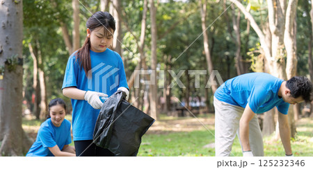 Diverse family volunteering for garbage collection in a park, promoting environmental awareness and community service. Diverse family volunteering for garbage collection in a park, promoting environmental awareness and community service. 125232346