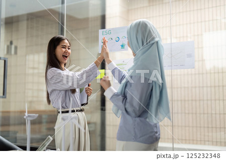 Joyful Collaboration for ESG Initiatives. Professionals celebrating progress in sustainability efforts through collaboration. 125232348