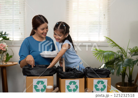 Eco-Parenting and Environmental Stewardship. A mother and child recycling together, promoting green habits in daily life. Eco-Parenting and Environmental Stewardship. A mother and child recycling together, promoting green habits in daily life. 125232518