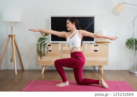 Yoga and Balance. A woman practicing low lunge pose, focusing on balance and stability. 125232609