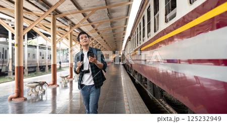Travel and Rail Adventure. A traveler eagerly explores the train station, ready for an exciting journey. Travel and Rail Adventure. A traveler eagerly explores the train station, ready for an exciting journey. 125232949