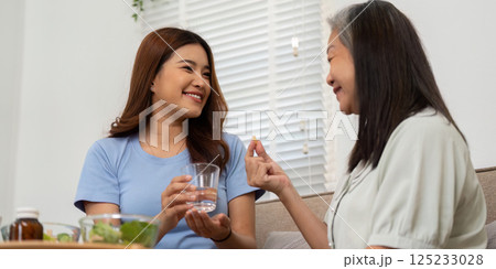 Wellness and Conversation. A joyful interaction between a mother and senior asking about wellness and nutrition. Wellness and Conversation. A joyful interaction between a mother and senior asking about wellness and nutrition. 125233028