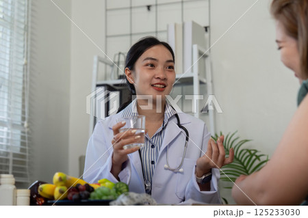 Nutrition and Consultation. A nutritionist discussing dietary options with a patient in a bright consultation room. 125233030
