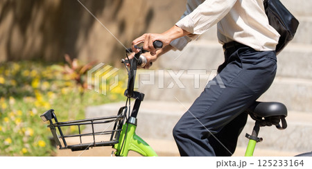 Active Transportation and Eco-Friendliness. The young cyclist prepares to ride, showcasing a green bicycle and displaying his water bottle, promoting sustainable commuting. 125233164