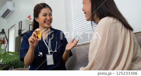Patient Care and Medication Discussion. A nurse joyfully explains medication instructions to an elderly woman during a home visit. Patient Care and Medication Discussion. A nurse joyfully explains medication instructions to an elderly woman during a home visit. 125233306