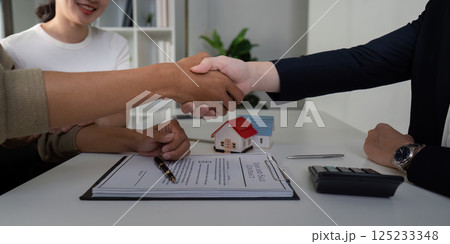 Closure and Business Agreement. A couple shakes hands with their real estate agent after concluding the sale. Closure and Business Agreement. A couple shakes hands with their real estate agent after concluding the sale. 125233348