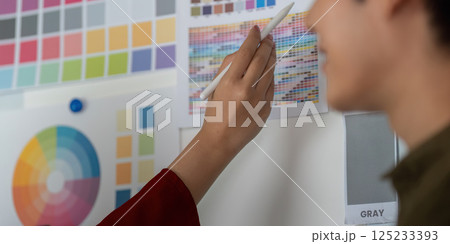Creative Ideation and Color Selection. Team member selects colors from a comprehensive palette for a project. Creative Ideation and Color Selection. Team member selects colors from a comprehensive palette for a project. 125233393