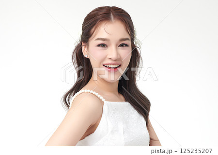 A beautiful young Asian woman with clean, fresh skin against a white background. Skincare, facial treatment, cosmetology, beauty, and spa. An elegant portrait of an Asian woman. A beautiful young Asian woman with clean, fresh skin against a white background. Skincare, facial treatment, cosmetology, beauty, and spa. An elegant portrait of an Asian woman. 125235207