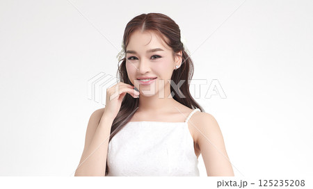 A beautiful young Asian woman with clean, fresh skin against a white background. Skincare, facial treatment, cosmetology, beauty, and spa. An elegant portrait of an Asian woman. A beautiful young Asian woman with clean, fresh skin against a white background. Skincare, facial treatment, cosmetology, beauty, and spa. An elegant portrait of an Asian woman. 125235208