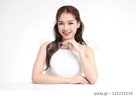 A beautiful young Asian woman with clean, fresh skin against a white background. Skincare, facial treatment, cosmetology, beauty, and spa. An elegant portrait of an Asian woman. 125235219