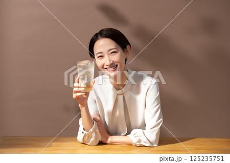 ハイボールを飲む女性　茶色 125235751