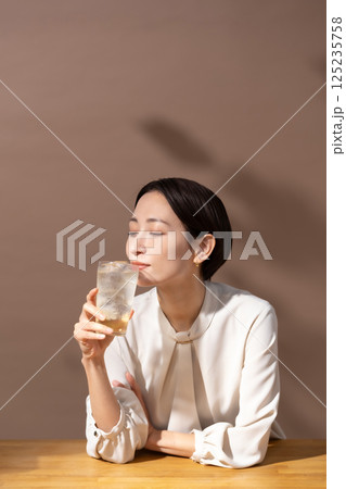 ハイボールを飲む女性　茶色 125235758