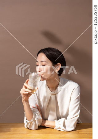 ハイボールを飲む女性　茶色 125235759