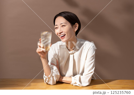 ハイボールを飲む女性　茶色 125235760