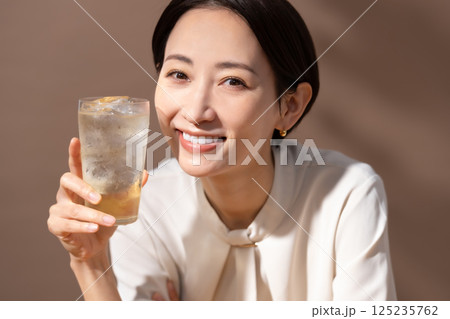 ハイボールを飲む女性　茶色 125235762