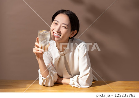 ハイボールを飲む女性　茶色 125235763