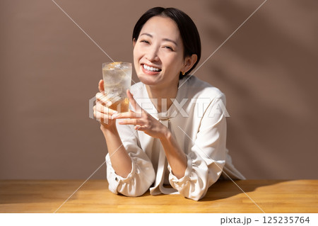 ハイボールを飲む女性　茶色 125235764
