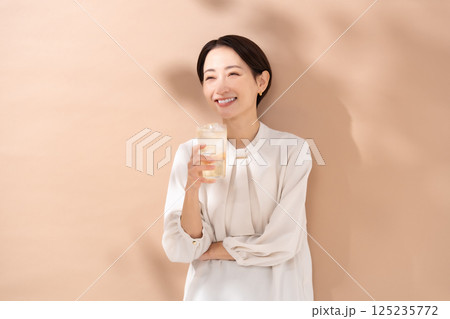 ハイボールを飲む女性　日差し 125235772