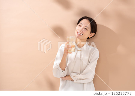 ハイボールを飲む女性　日差し 125235773
