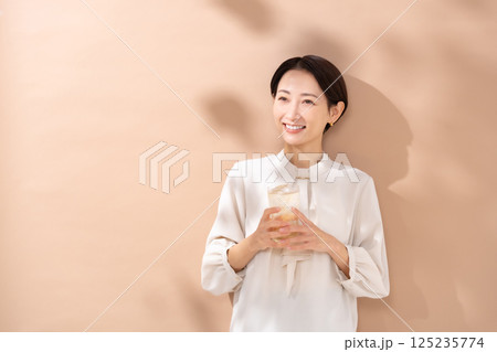 ハイボールを飲む女性　日差し 125235774