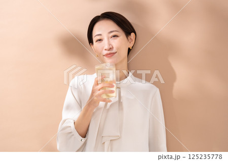 ハイボールを飲む女性　日差し 125235778